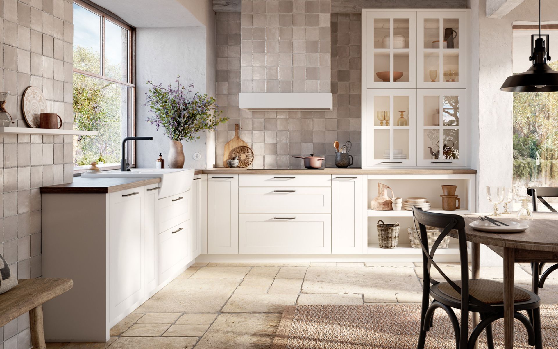 Cuisine équipée traditionnelle blanche avec coin repas, évier timbre d'office, vitrines décoratives et carrelage beige mural pour un charme rustique et chaleureux. IDEO cuisines sur mesure